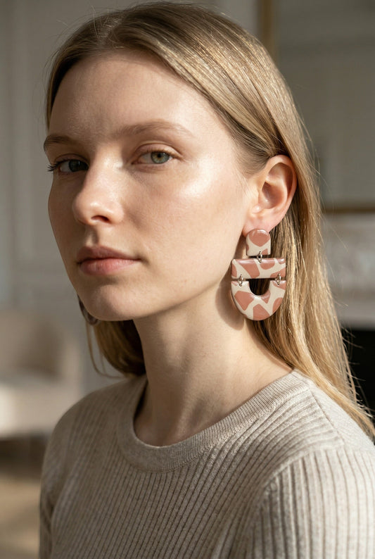 Lakelynns Designs abstract arch dangle earrings in beige with pink spots, made of polymer clay.