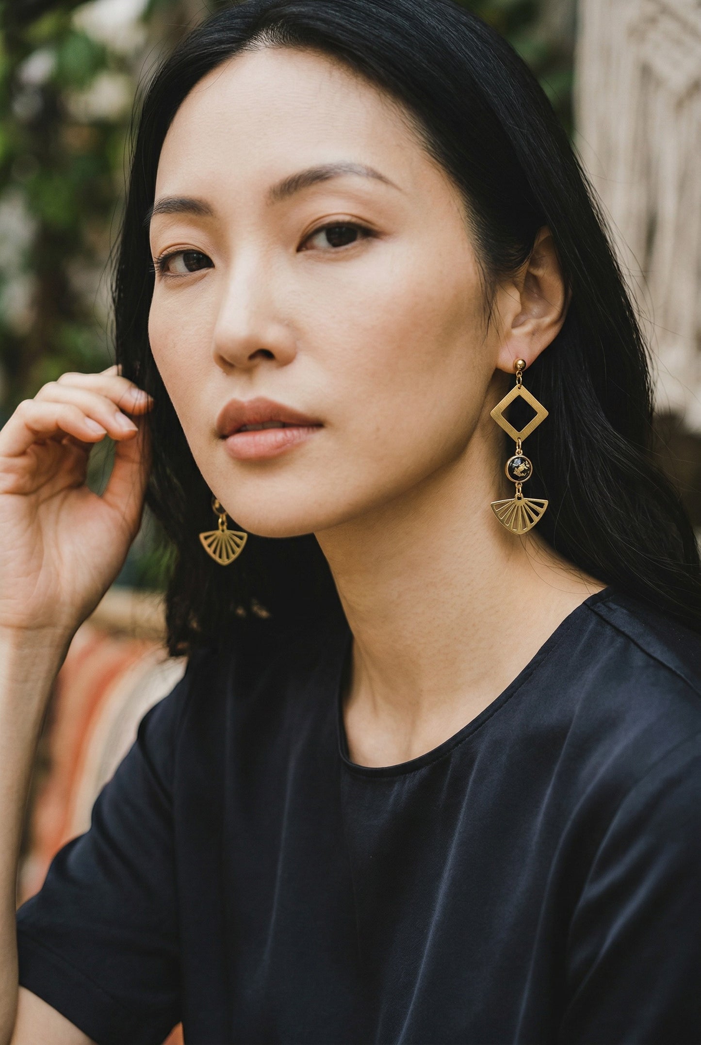 Lakelynns Designs gold-tone geometric fan statement earrings with black cabochon and gold flecks.