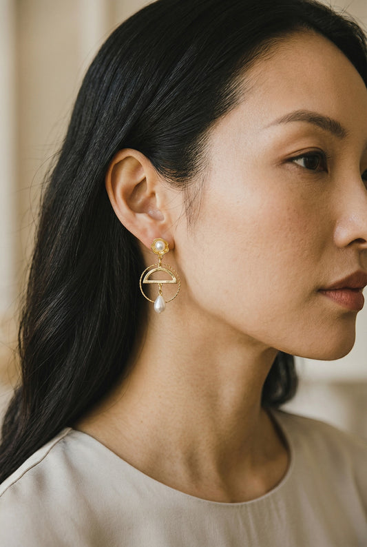 Lakelynns Designs geometric gold-tone earrings with pearl drop. Features a semi-circular frame and a dangling pearl.