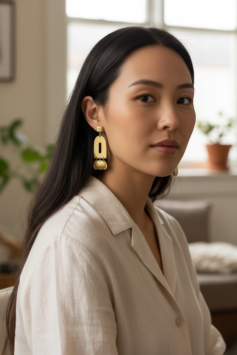 Lakelynns Designs Modern Arch Dangle Earrings in brushed brass with geometric cutout and coin charms.