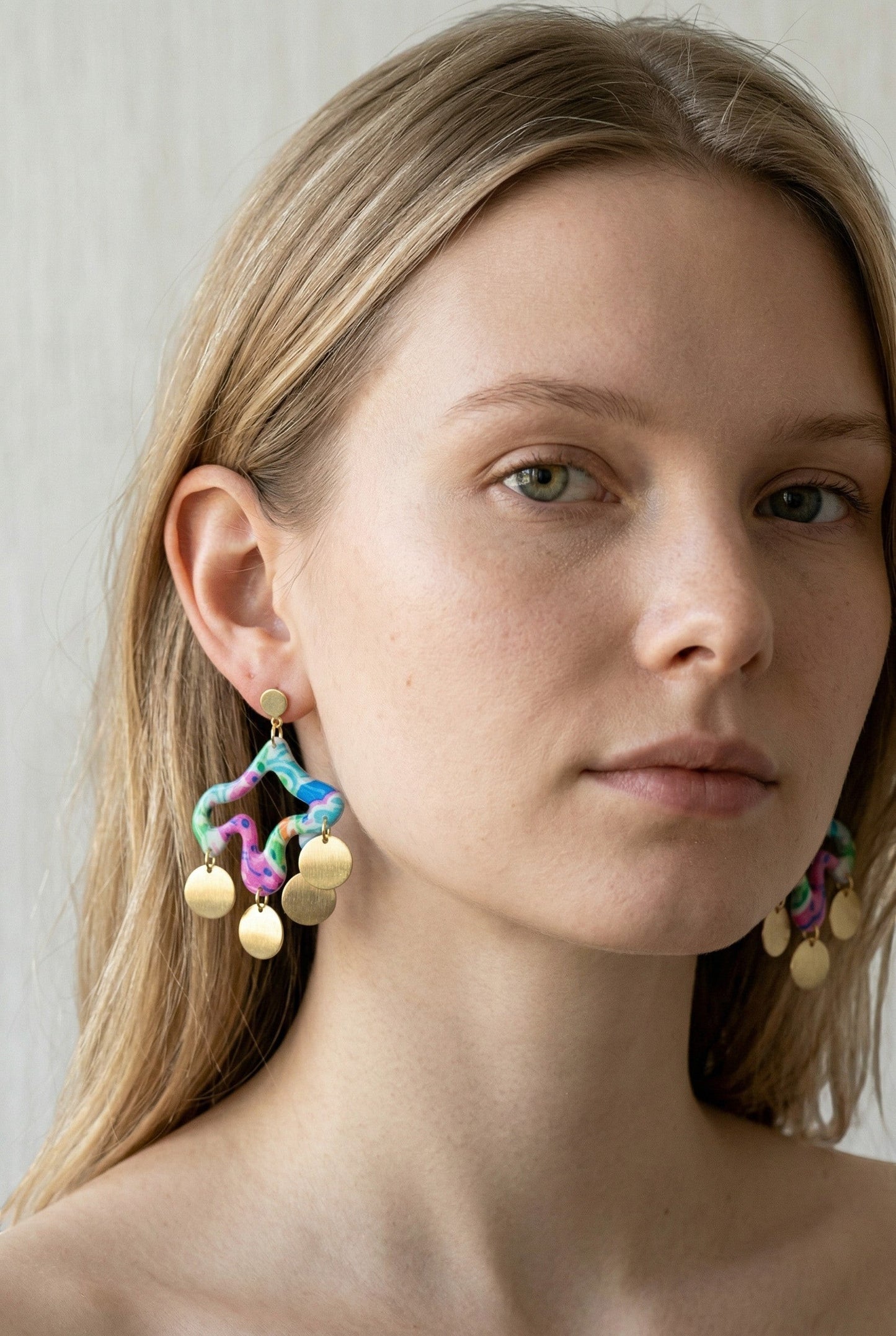 Lakelynns Designs abstract polymer clay dangle earrings with brass discs in pink, blue, green, and orange.