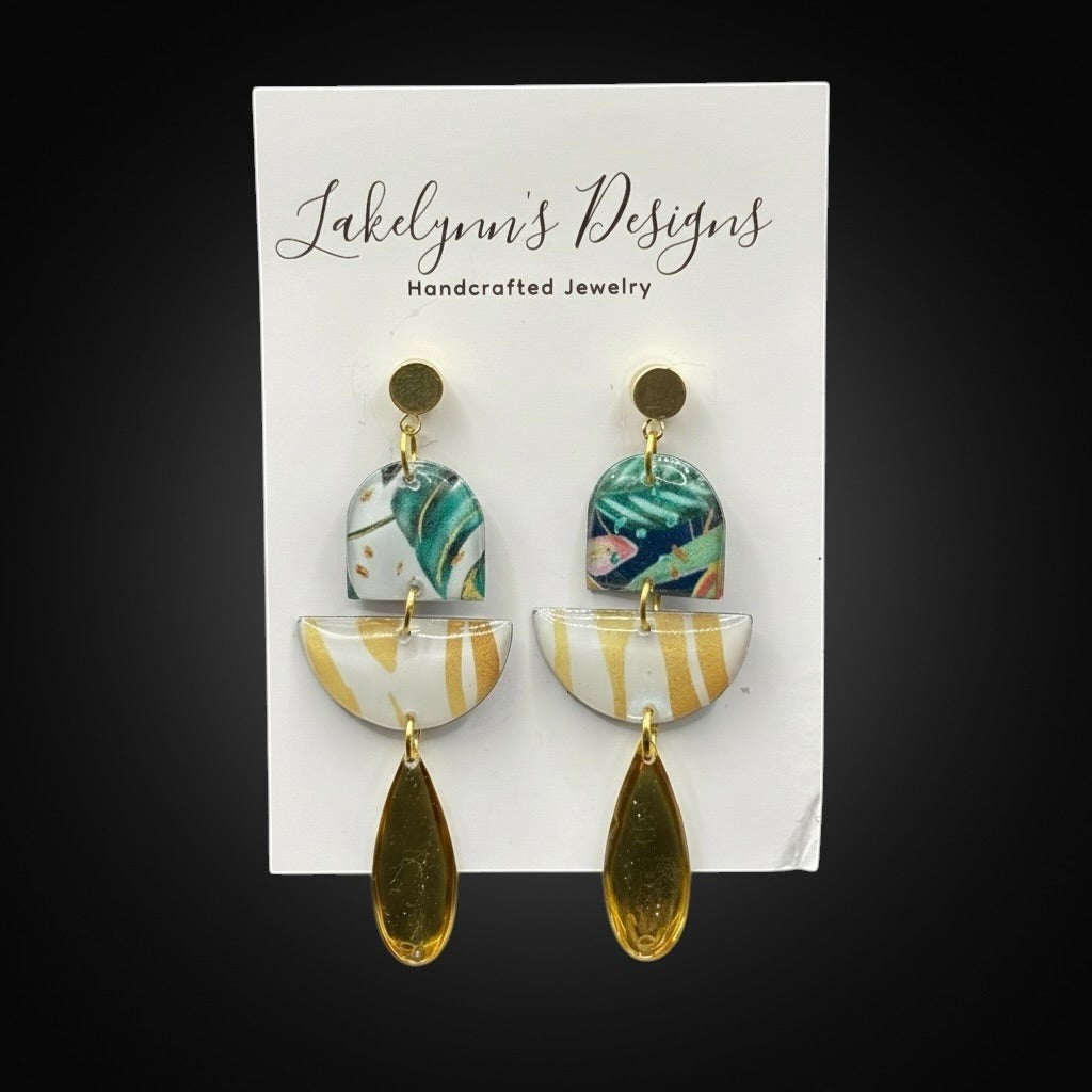 Lakelynns Designs abstract dangle earrings with tropical foliage, gold stripes, and teardrop pendants.