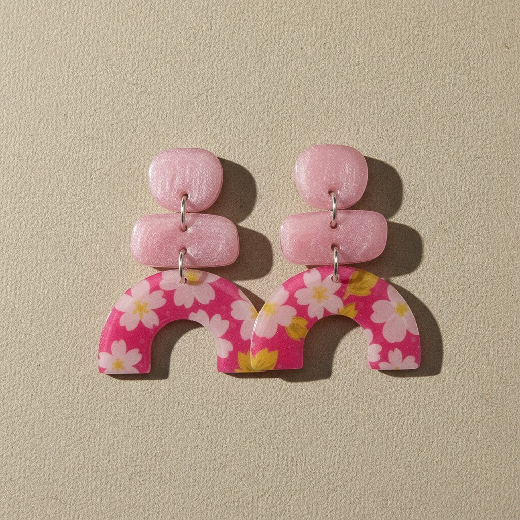 Lakelynns Designs abstract floral arch earrings in pink with white flowers and yellow accents. Lightweight resin.