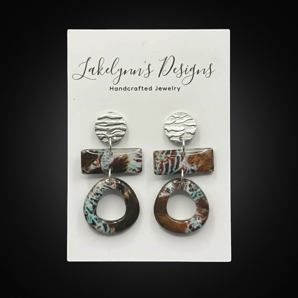 Lakelynns Designs abstract geometric dangle earrings with silver-tone discs, marbled brown and teal rectangular elements, and circular dangles.