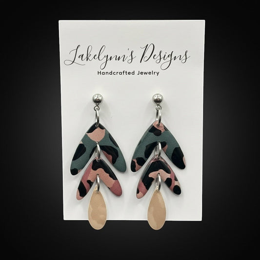 Lakelynns Designs abstract leaf dangle earrings in teal, dusty rose, black, and champagne. Polymer clay with hypoallergenic posts.
