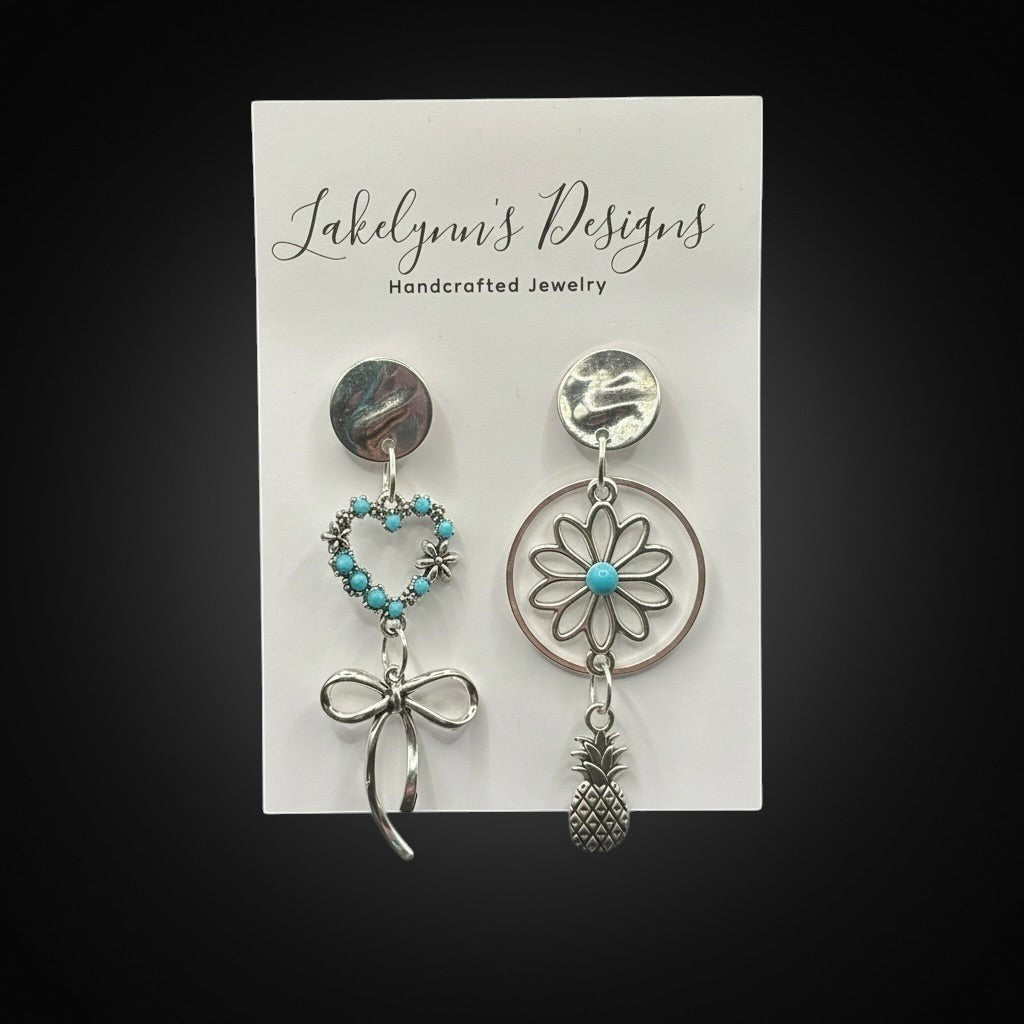Lakelynns Designs asymmetrical silver-tone earrings with turquoise heart, bow, flower, and pineapple charms.