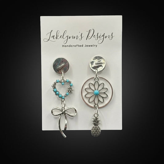 Lakelynns Designs asymmetrical silver-tone earrings with turquoise heart, bow, flower, and pineapple charms.