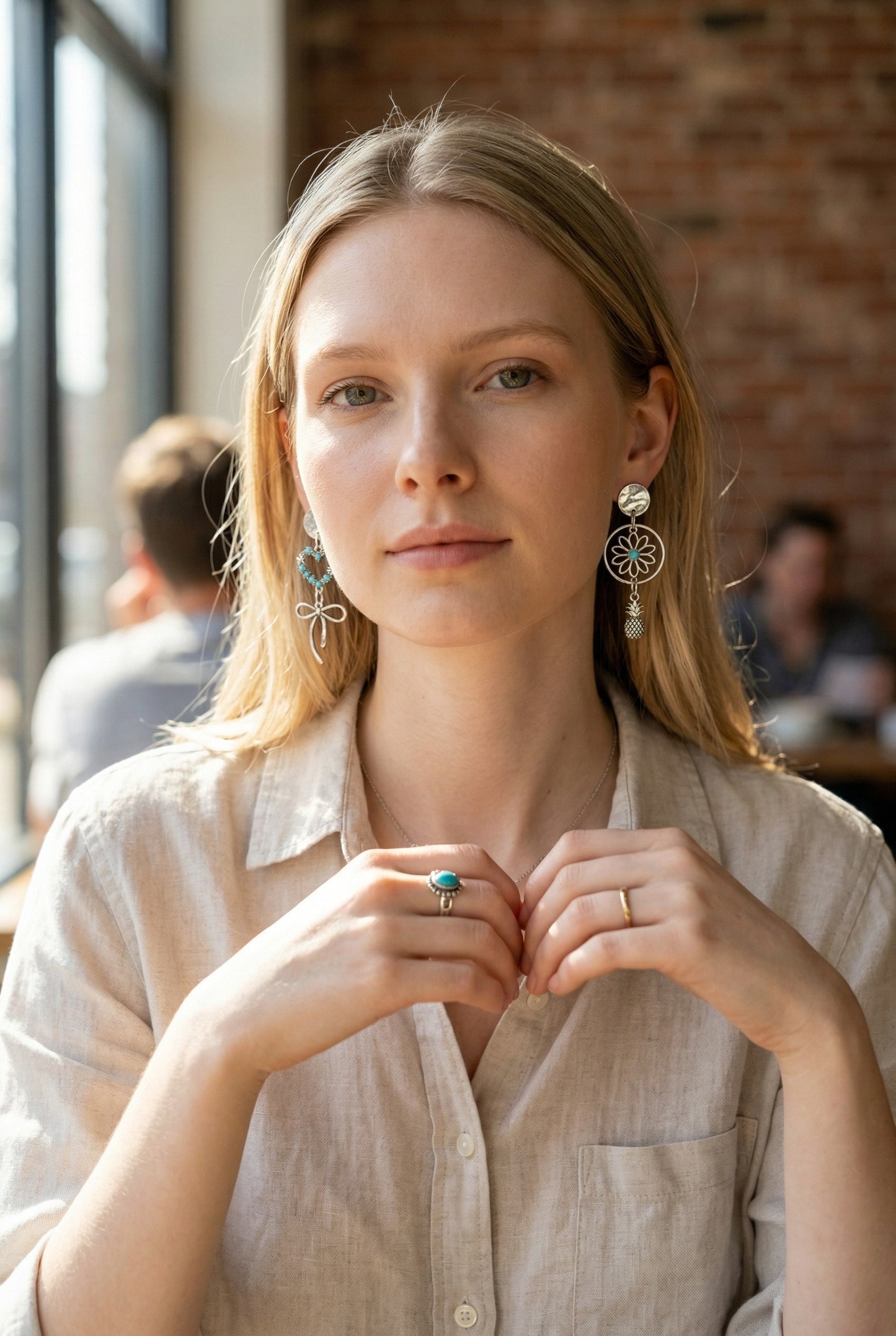 Lakelynns Designs asymmetrical silver-tone earrings with turquoise stones, one a heart with bow, the other a flower with pineapple charm.