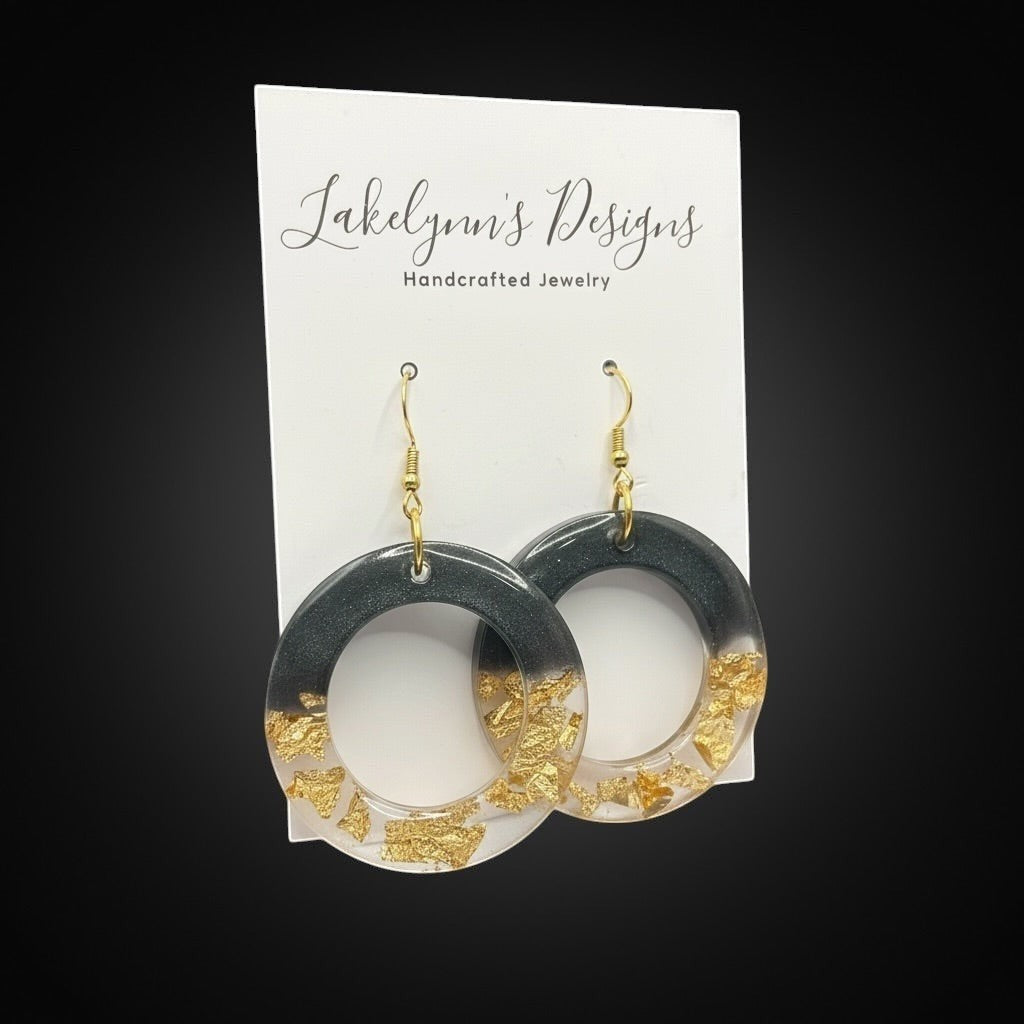 Lakelynns Designs black and gold round hoop earrings with gold flakes embedded in charcoal grey resin. Lightweight statement jewelry.