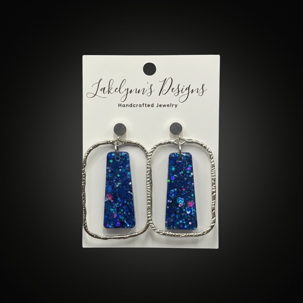 Lakelynns Designs blue glitter resin rectangular dangle earrings with textured silver-tone frames.