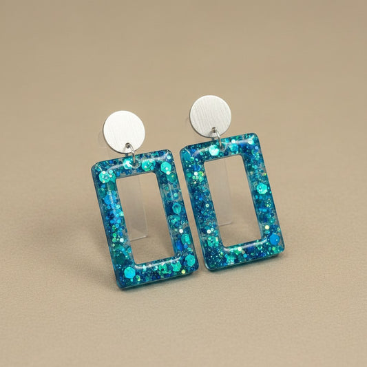 Lakelynns Designs blue and teal glitter resin rectangle drop earrings with silver studs.