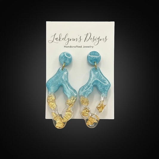 Lakelynns Designs blue and gold abstract geometric dangle earrings with translucent resin and gold flakes.