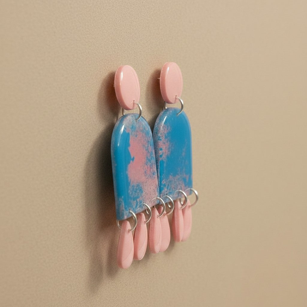 Lakelynns Designs blue marbled polymer clay arch dangle earrings with pink teardrop accents.