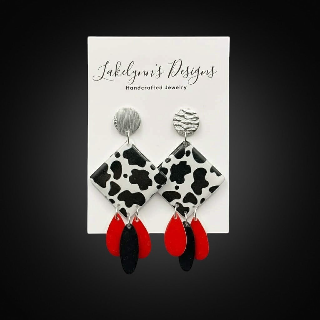 Lakelynns Designs cow print dangle earrings with red and black teardrop charms and silver-tone studs.