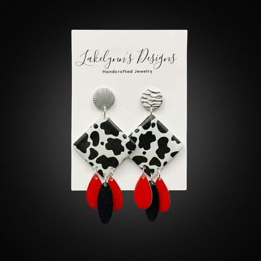 Lakelynns Designs cow print dangle earrings with red and black teardrop charms and silver-tone studs.