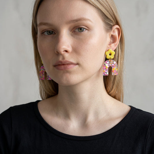 Lakelynns Designs yellow flower stud earrings with translucent glitter-filled arches in pink, purple, and yellow.