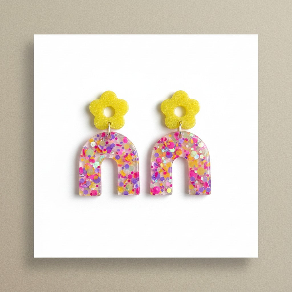 Lakelynns Designs yellow flower stud earrings with translucent glitter-filled arches in pink, purple, and yellow.