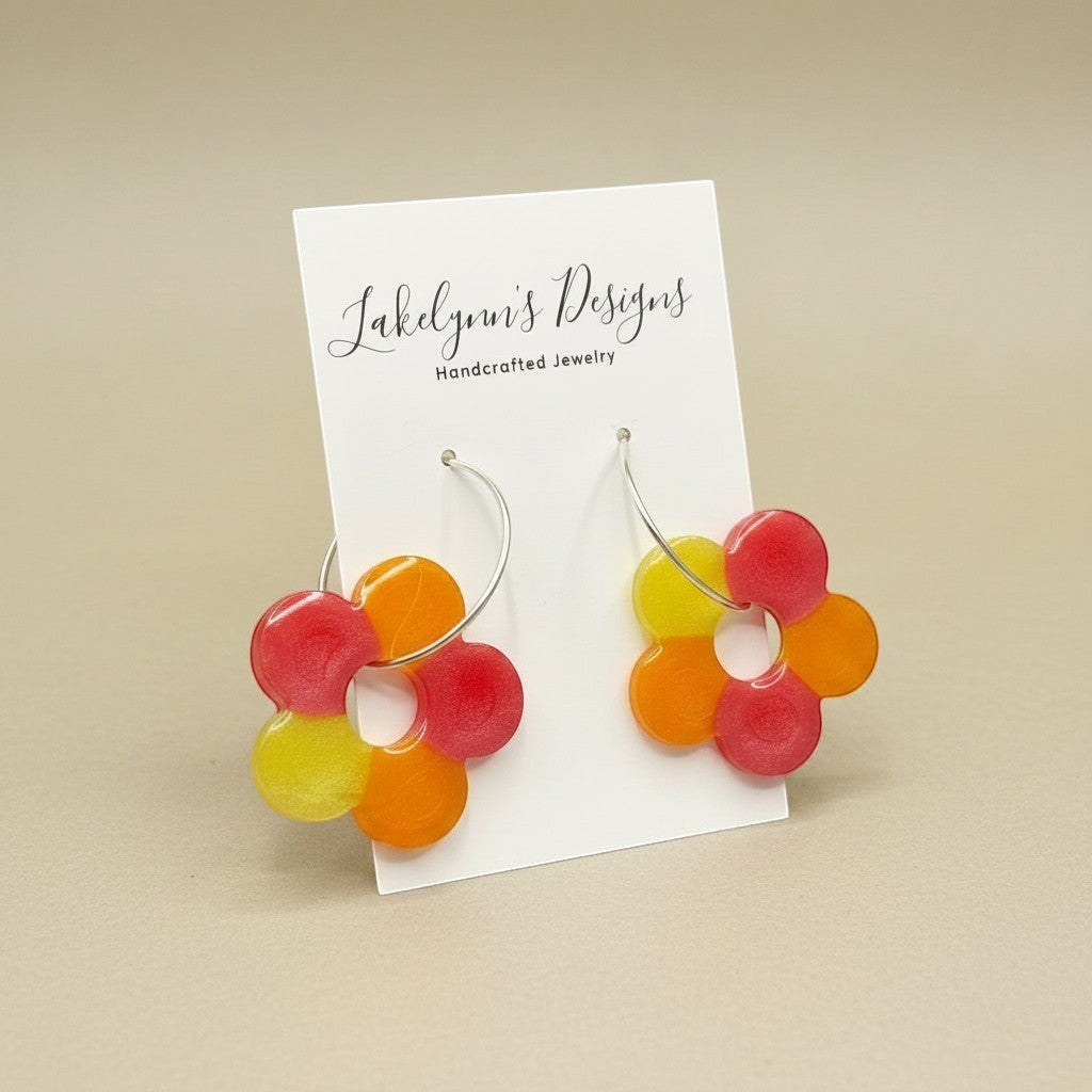 Lakelynns Designs colorful flower hoop earrings in red, orange, and yellow translucent resin.