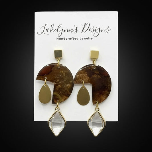 Lakelynns Designs marbled brown resin geometric statement earrings with gold accents and crystal drops.