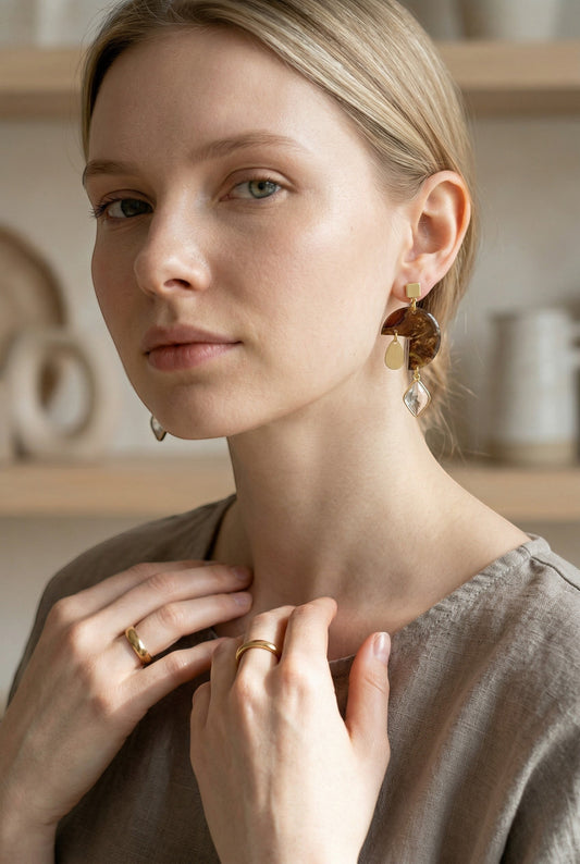 Lakelynns Designs geometric statement earrings with marbled brown resin, gold accents, and crystal drop.