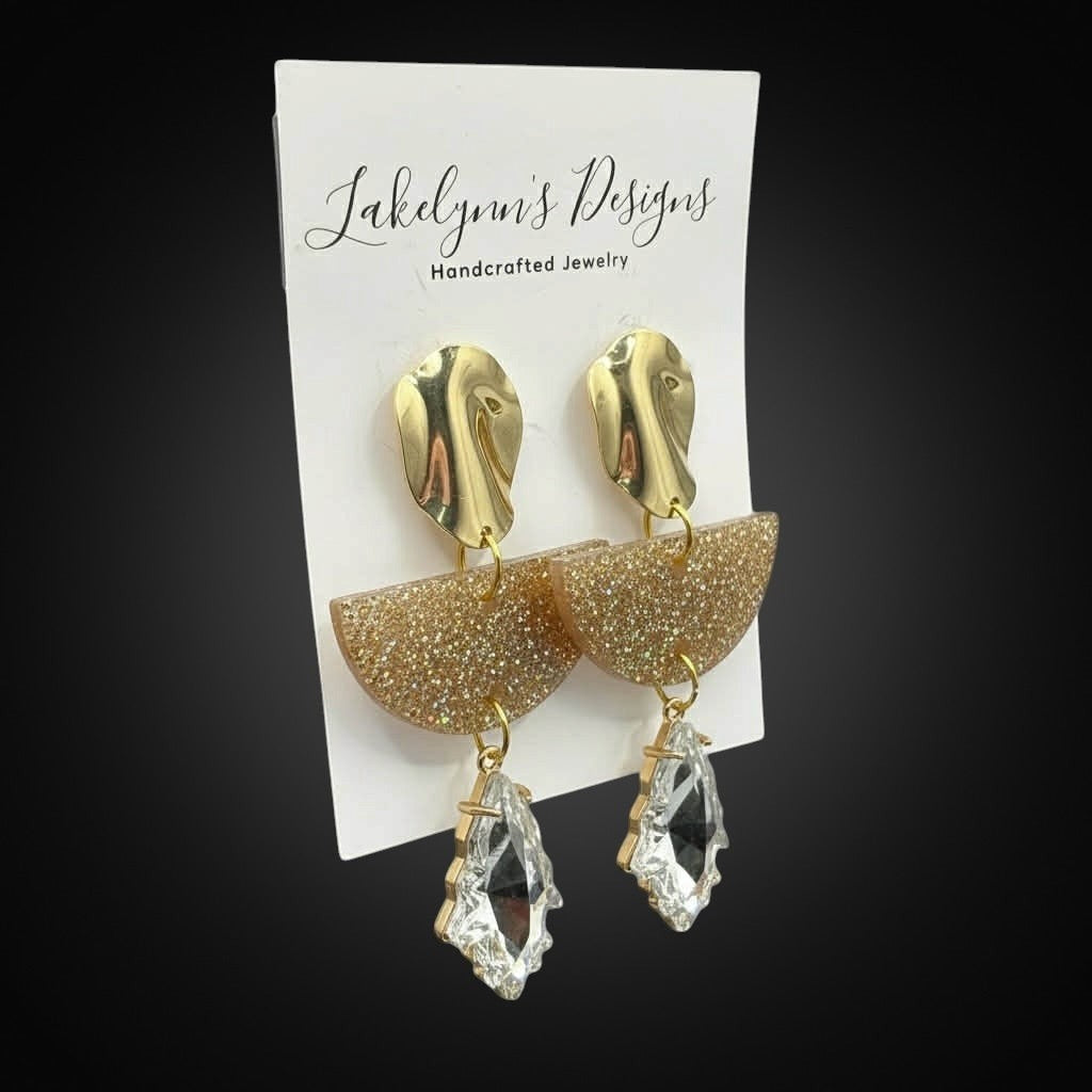 Lakelynns Designs geometric statement earrings with gold abstract tops, glitter resin half-moons, and clear crystal drops.
