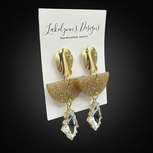 Lakelynns Designs geometric statement earrings with gold abstract tops, glitter resin half-moons, and clear crystal drops.