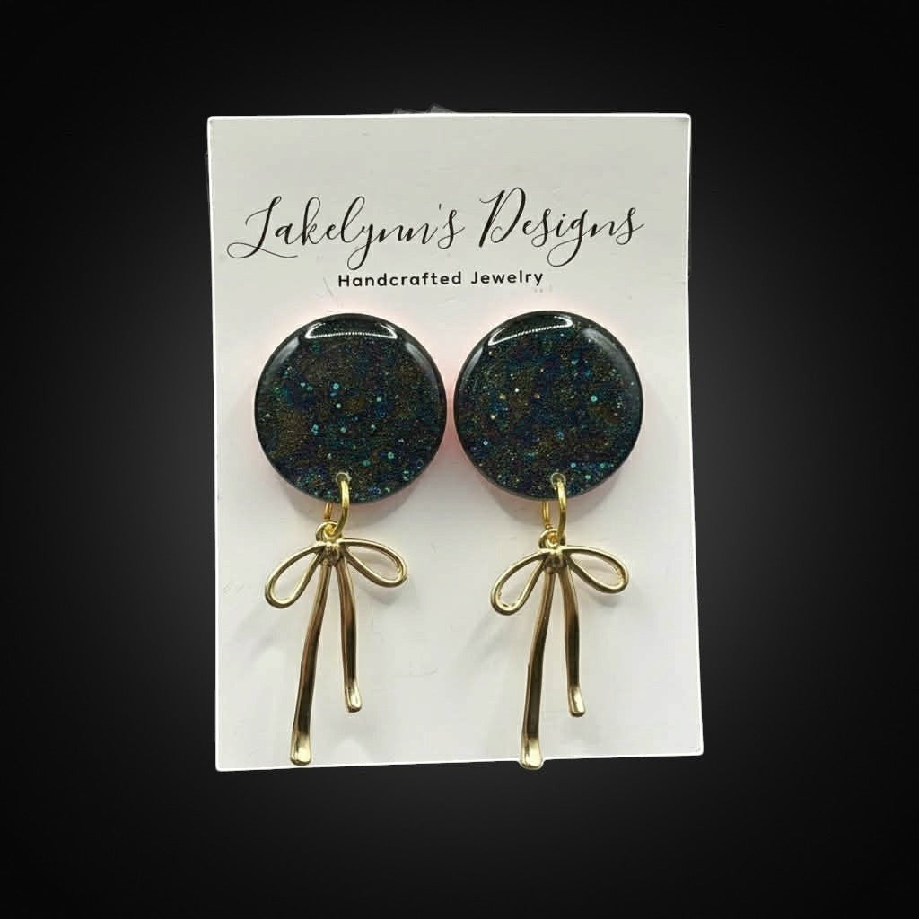 Lakelynns Designs round glitter earrings with gold-tone bow dangles. Dark blue and green glitter with gold accents.