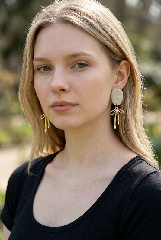Lakelynns Designs Kinsley Glitter Oval Dangle Earrings with gold-tone bow charms.