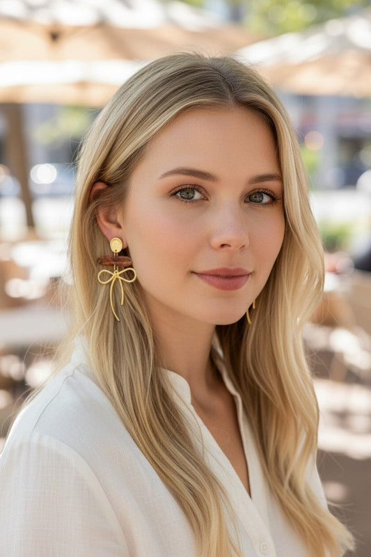 Lakelynns Designs gold bow dangle earrings with marbled acrylic bead and gold-tone stud.