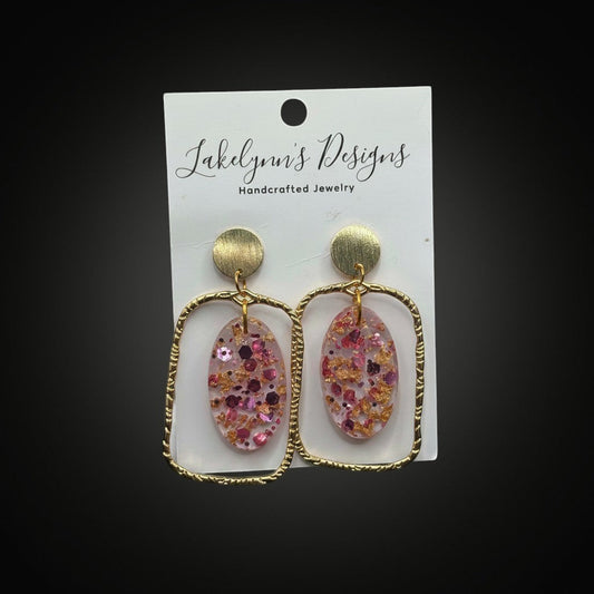 Lakelynns Designs gold geometric earrings with pink and gold glitter oval resin inserts. Modern, handcrafted jewelry.