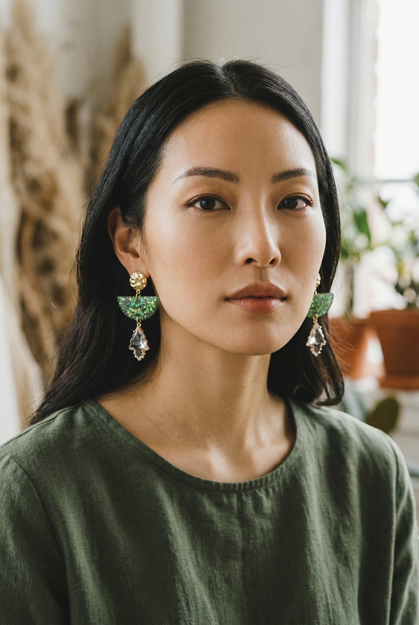 Lakelynns Designs emerald green glitter half moon resin earrings with clear crystal dangles and gold studs.