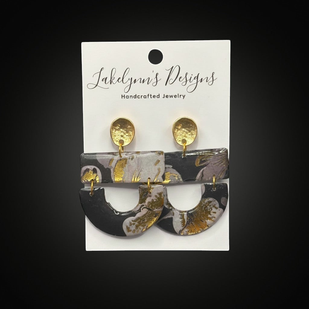 Lakelynns Designs Hollis dangle earrings with abstract black, grey, and gold marbled pattern. Lightweight polymer clay with gold-toned hardware.