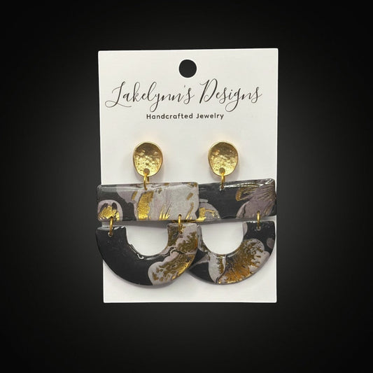 Lakelynns Designs Hollis dangle earrings with abstract black, grey, and gold marbled pattern. Lightweight polymer clay with gold-toned hardware.