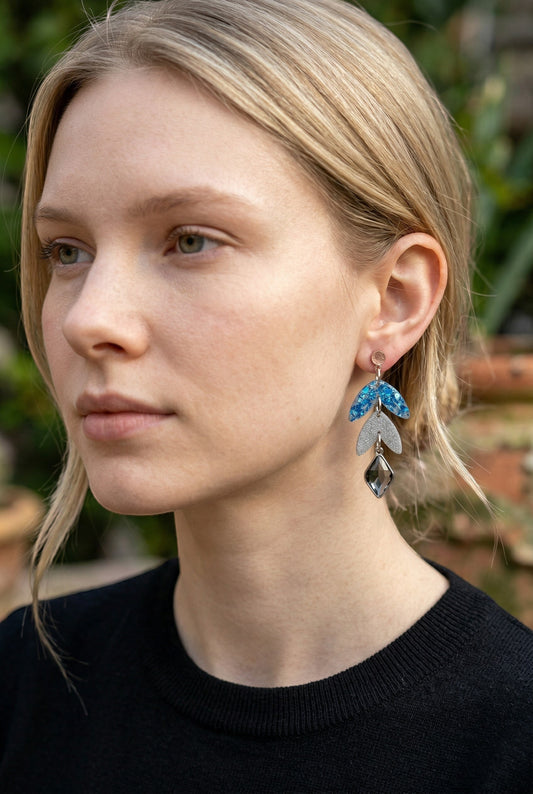 Lakelynns Designs layered leaf dangle earrings in blue glitter resin, silver glitter acrylic, and charcoal grey charm.