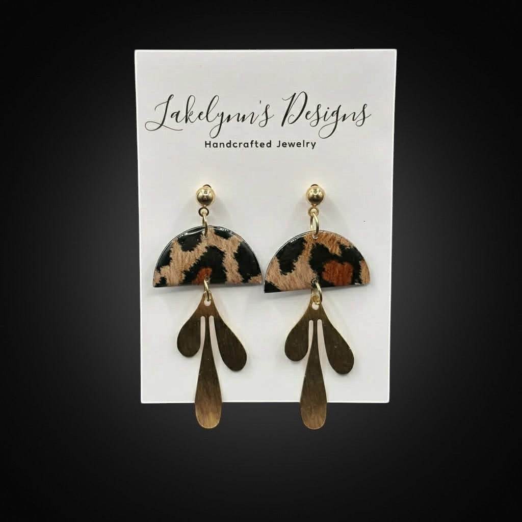 Lakelynns Designs leopard print dangle earrings with abstract gold charms. Semi-circular top with animal print.