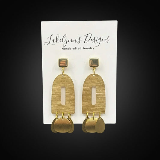 Lakelynns Designs Modern Arch Dangle Earrings in brushed brass with cutout detail and coin charms.