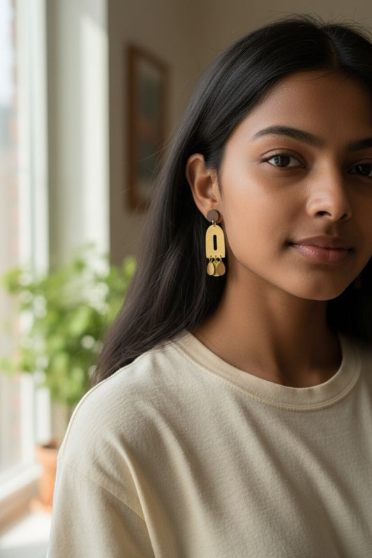 Lakelynns Designs modern arch dangle earrings in gold with textured finish and dangling circular charms.