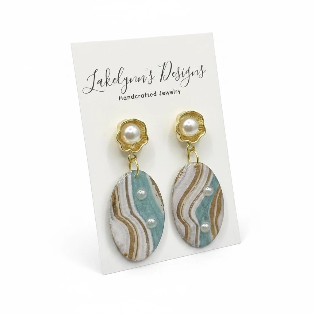 Lakelynns Designs oval dangle earrings with pearl accents, featuring aqua, cream, and gold marbled design.