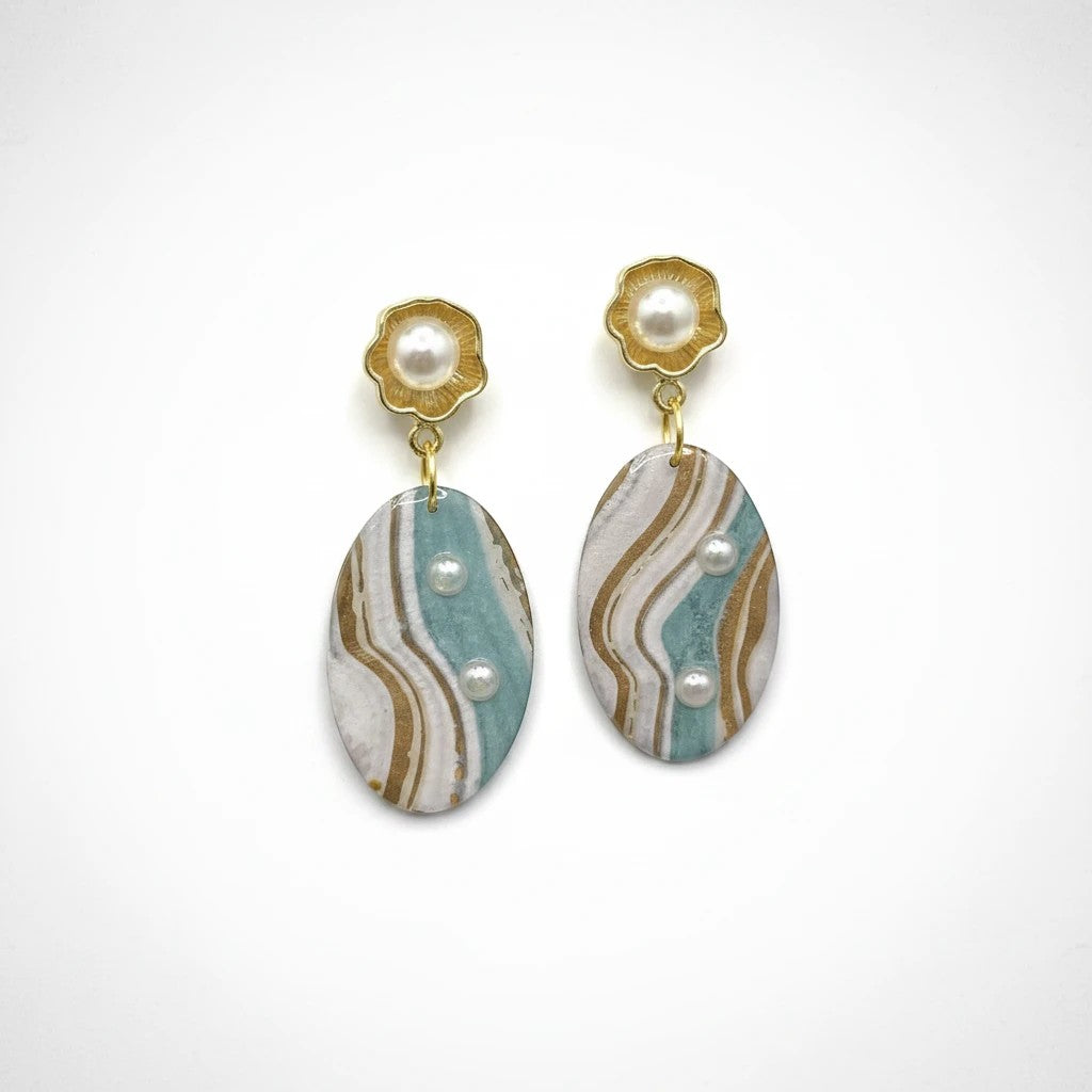 Lakelynns Designs oval dangle earrings with marbled aqua, cream, and gold design, featuring pearl accents and gold floral studs.