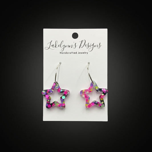Lakelynns Designs star shaped hoop earrings with multi-colored glitter in clear resin. Silver-toned hook closure.