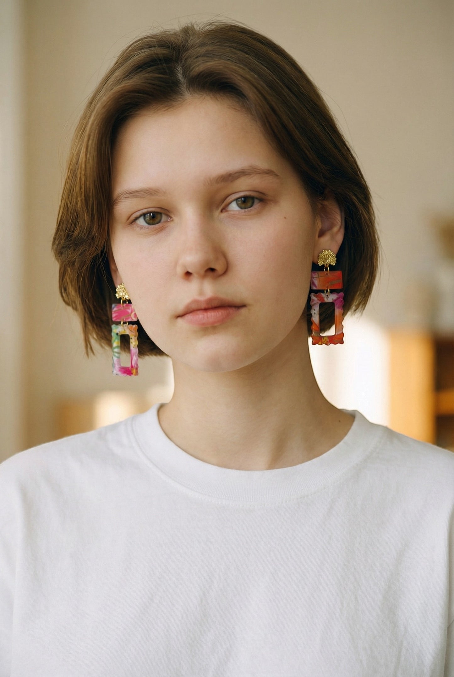 Lakelynns Designs rectangular statement earrings with gold-tone stud tops, featuring vibrant pink, orange, and green abstract patterns on a translucent background.