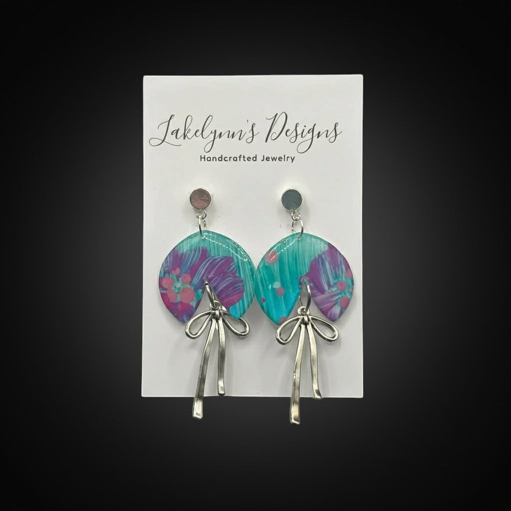 Lakelynns Designs Wren Teal and Purple Swirl Bow Earrings with silver-tone bow charms.