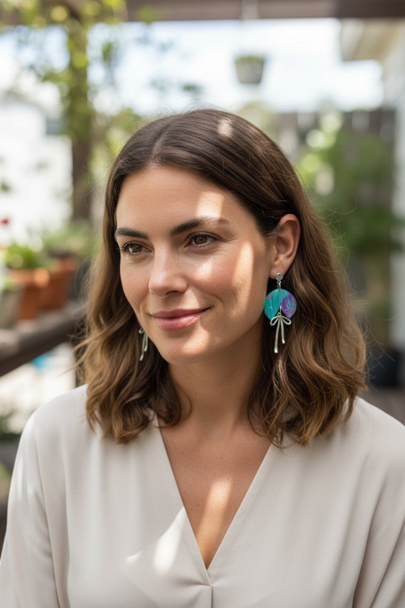 Lakelynns Designs Teal and Purple Swirl Bow Earrings with silver-tone bow detail. Artistic, handcrafted statement earrings.