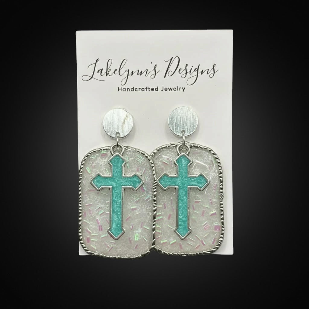 Lakelynns Designs turquoise cross earrings with glitter resin and silver rope edge detail.