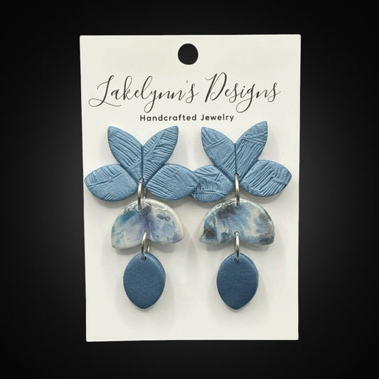 Lakelynns Designs Xandra blue floral statement earrings with marbled semi-circle charms and teardrop accents, made of polymer clay.